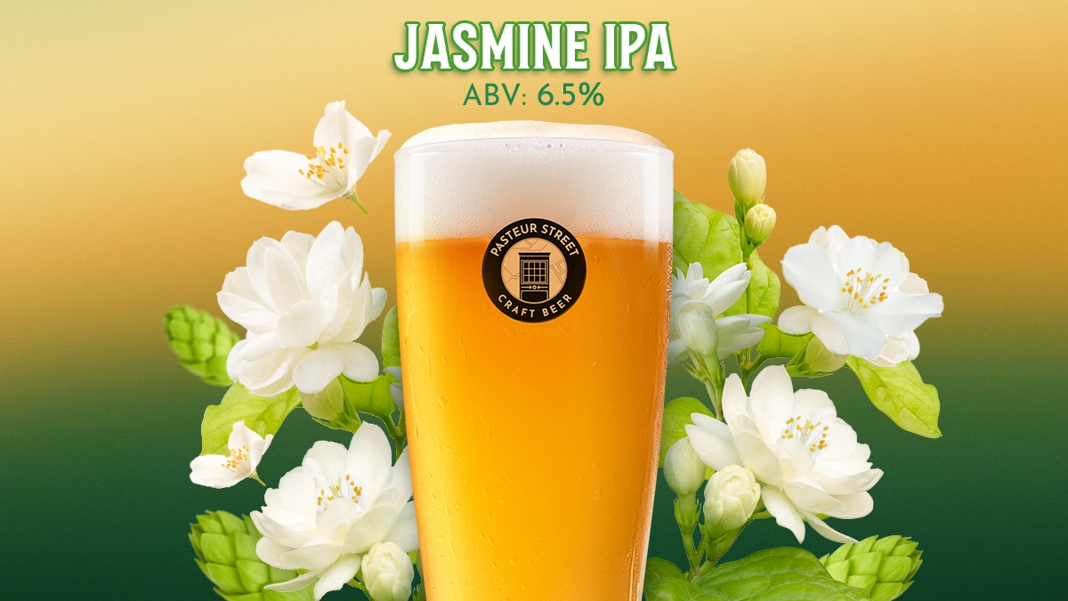 A glass of Pasteur Street Jasmine IPA, a golden craft beer surrounded by fresh white jasmine flowers and green hops.